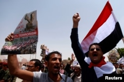 FILE - People shout slogans in support of the Yemen army and security forces in a U.S.-backed campaign against militant network al-Qaida in the Arabian Peninsula (AQAP), in Sana'a, May 21, 2014.