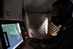 FILE - An Ecuadorian navy officer looks at a radar after a fishing fleet of mostly Chinese-flagged ships was detected in an international corridor that borders the Galapagos Islands' exclusive economic zone, in the Pacific Ocean, Aug. 7, 2020.