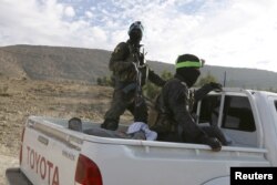 FILE - Members of the People's Protection Units (YPG), fighting alongside the Democratic Forces of Syria, ride on a truck during what they said was an offensive against Islamic State militants to take control of Tishrin dam near Kobani, Kobani, Syria, Dec. 26, 2015.