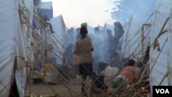 Cooking fires cloud the air with smoke around the maze of tents.
