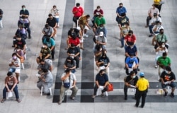 People wearing protective masks queue outside the Central Vaccination Center as people look to get vaccinated against COVID-19 in Bangkok on July 22, 2021. Chalinee Thirasupa/Reuters