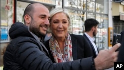 French far-right leader and candidate for the 2017 presidential election Marine Le Pen poses for a selfie in Paris, April 24, 2017.