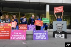 Protesters gather outside the County Court during the sentencing of Cardinal George Pell in Melbourne, Australia, Wednesday, March.13, 2019.