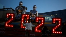 A child wearing a face mask, following the coronavirus disease (COVID-19) outbreak, walks in front of a 2022 installation on New Year's Eve at a shopping mall in Beijing, Dec. 31, 2021.