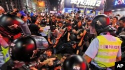 In this Nov. 26, 2014 file photo, police officers block pro-democracy protesters in the Mong Kok district during the Umbrella Movement in Hong Kong. (AP Photo/Kin Cheung, File)