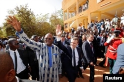 French President Emmanuel Macron and Burkina Faso's President Roch Marc Christian Kabore leave the Ouagadougou University, in Ouagadougou, Burkina Faso, Nov. 28, 2017.