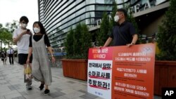 A protester stands to oppose South Korean President Moon Jae-in's possible visit to Japan in front of a building which houses Japanese embassy in Seoul, South Korea, Monday, July 19, 2021. Moon has decided not to visit Japan for the Tokyo Summer…