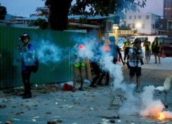 Journalists work near tear gas canisters deployed during a face-off between police and protesters at the Yuen Long district in Hong Kong on Saturday, July 27, 2019.