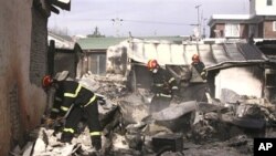 South Korean firefighters inspect destroyed houses on Yeonpyeong island, South Korea, 24 Nov 2010