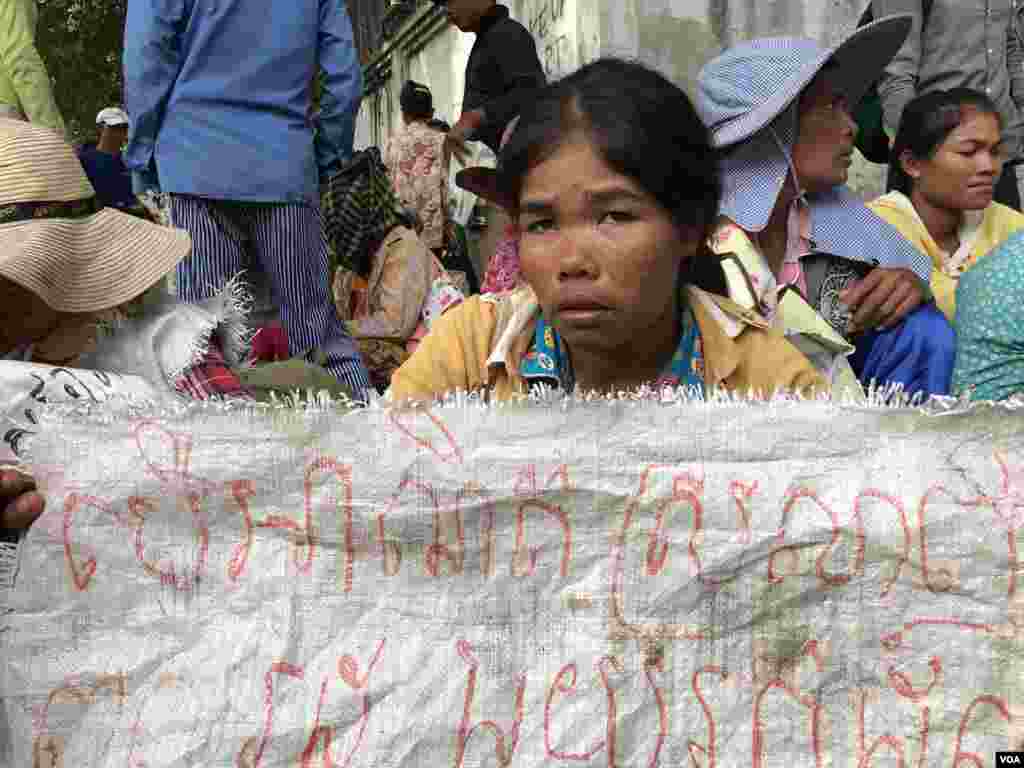 ស្ត្រីអ្នកតវ៉ា​មួយរូបកាន់​បដា​អំពាវនាវឲ្យមាន​ដំណោះស្រាយ​ដីធ្លី​នៅ​ក្រសួង​រៀបចំដែន​ដី​ ទីក្រុង​ភ្នំពេញ​ ថ្ងៃទី​២២​ ខែសីហា​ ឆ្នាំ​២០១៩។ (ហ៊ុល រស្មី/VOA)