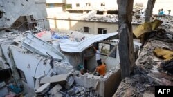 Wapalestina wakitathmini uharibifu kufuatia shambulizi la Israel katika kambi ya wakimbizi ya Nuseirat, Julai 6, 2024. Picha ya AFP