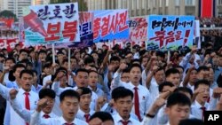 North Koreans gather at Kim Il Sung Square for a mass rally against America, Sept. 23, 2017, in Pyongyang, North Korea, a day after the country's leader issued a rare statement attacking Donald Trump. The sign on the left reads "decisive revenge" and the sign on the right reads "death to the American imperialists." 