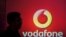FILE PHOTO: A man casts silhouette onto an electronic screen displaying logo of Vodafone India after a news conference in Mumbai, India, Nov. 10, 2015. 