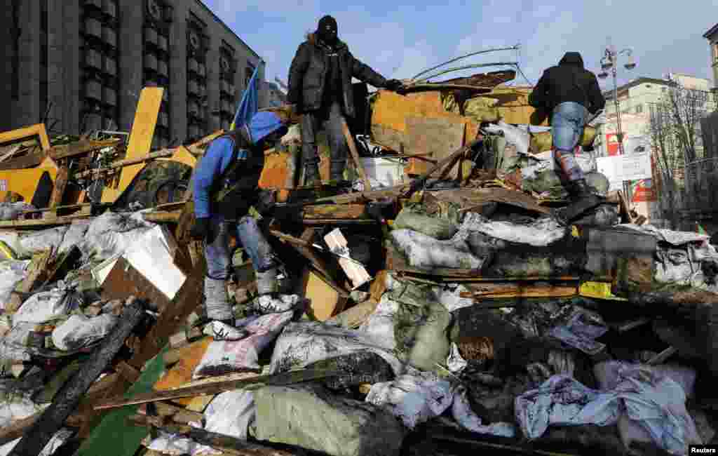 Anti-government protesters climb a barricade in central Kyiv, Feb. 20, 2014.&nbsp;
