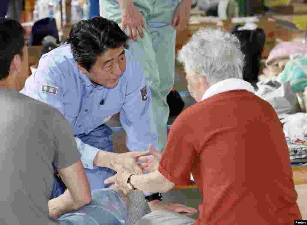 日本首相安倍晋三在日本冈山县仓敷市的一个疏散中心与当地居民会面，这张照片是日本共同社于2018年7月11日拍摄的。
