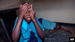 School pupils react after being teargassed by police who were confronting a demonstration near their school in the Kamwokya area of Kampala, Uganda, Thursday, Aug. 16, 2018. Supporters were demonstrating in support of pop singer and prominent critic of Uganda's government Kyagulanyi Ssentamu.