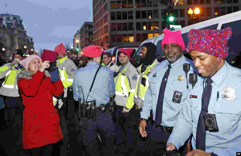 A woman takes a picture of Washington Metropolitan Police Department officers wearing pink hats as marchers fill 17th Street after the Women&#39;s March on Washington, Saturday, Jan. 21, 2017 in Washington. (AP Photo/Alex Brandon)