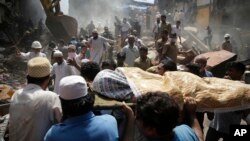 The body of a victim is carried out from the site of a building collapse in Mumbai, India, Aug. 31, 2017. A five-story building collapsed Thursday in Mumbai, Indian’s financial capital, after torrential rains lashed western India.