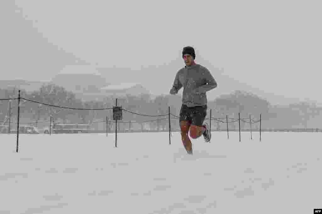 A man runs along the National Mall as snow falls during a winter storm in Washington, Jan. 6, 2025. 