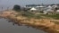 FILE - People are seen by the bank of Benue River in Makurdi, Nigeria, Nov. 29, 2018. Massive flooding is expected this month on the Niger and Benue rivers. 