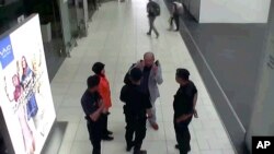 Gambar CCTV bandara yang didistribusikan oleh Fuji Television, Kim Jong-nam, saudara tiri pemimpin Korea Utara, Kim Jong-un, yang diasingkan membuat gerakan ke arah mukanya ketika berbicara pada keamanan bandara dan para petugas di Bandara Internasional Kuala Lumpur Malaysia. (foto: Fuji Television via AP)