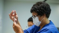 Seorang petugas kesehatan mengisi jarum suntik dengan vaksin COVID-19 Pfizer-BioNTech, untuk disuntikkan kepada para petugas vaksinasi di Auckland, Selandia Baru, 19 Februari 2021.