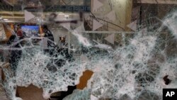 Bank employees are seen through the broken facade of Bank of Beirut that was smashed by anti-government protesters in Beirut, Lebanon, Jan. 15, 2020. 