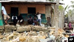 Local residents look at rubble and other items washed close to their doorstep when Cyclone Kenneth struck, in Pemba city on the northeastern coast of Mozambique, April, 27, 2019.