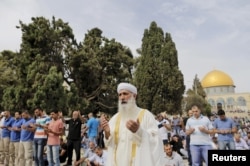 FILE - The Dome of the Rock is seen in the background as Palestinian men take part in Friday prayers on the compound known to Muslims as Noble Sanctuary and to Jews as Temple Mount in Jerusalem's Old City, Oct. 23, 2015.