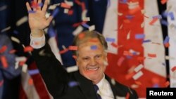 លោក ​Doug Jones បាន​លើក​ដៃ​ទៅ​កាន់​អ្នក​គាំទ្រ​ក្នុង​ពិធី​ជប់លៀង​ជ័យ​ជម្នះ​​អាសនៈ​​ព្រឹទ្ធសភា​ស.រ.អា.​ រដ្ឋ​ Alabama កាល​ពី​ថ្ងៃទី​១២ ខែ​ធ្នូ។