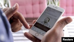 FILE - A man scrolls down his cellphone for social media newsfeed about Ethiopian Prime Minister Abiy Ahmed winning the Nobel Peace Prize in Addis Ababa, Ethiopia, Oct. 11, 2019. 