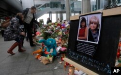 Portraits of two plane crash victims Natalia Soldatulina and Alexandra Pilip are placed near flowers and toys at an entrance of Pulkovo airport outside St. Petersburg, Russia, Nov. 4, 2015.