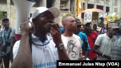 Robert Lipothy, un ancien migrant, en campagne de sensibilisation contre l’immigration clandestine au lieu dit avenue Kennedy à Yaoundé, Cameroun, 7 avril 2017. (VOA/Emmanuel Jules Ntap)
