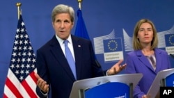 Menlu AS John Kerry (kiri) bersama representatif dari Uni Eropa, Federica Mogherini dalam konferensi pers di Brussels (27/6).