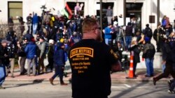 A man wearing an Oath Keepers shirt stands outside the Kenosha County Courthouse, in Kenosha, Wis., Nov. 19, 2021.