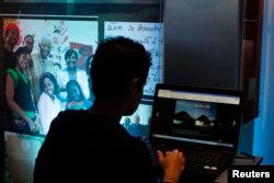 FILE - A visitor looks at the online Nelson Mandela Digital Archive on a computer screen during its launch at the Nelson Mandela foundation, March 27, 2012.