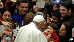 Pope Francis is cheered by faithful as he arrives for a special audience granted to some of the employees of the "Bambin Gesu "pediatric hospital in the Paul VI hall, at the Vatican, Thursday, Dec. 15, 2016. 