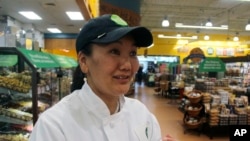 In this April 3, 2018, photo, mountain climber Lhakpa Sherpa prepares to start her shift as a dishwasher at the Whole Foods Market in West Hartford, Conn. (AP Photo/Pat Eaton-Robb)