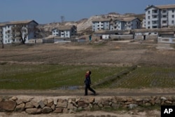 A North Korean boy walks along a path in front of a village on a road south of Kaesong, North Korea, April 24, 2013.