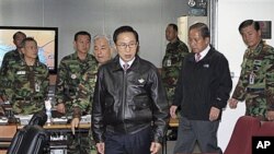 South Korean President Lee Myung-bak, center, arrives with Defense Minister Kim Tae-young, second right, in Seoul, South Korea, as the military was put on top alert after North Korea's artillery attack on the South Korean island of Yeonpyeong.