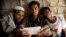 Rohingya Muslim refugee Mohammad Karim, 26, center, shows a mobile video of Gu Dar Pyin's massacre to other refugees in Kutupalong refugee camp, Bangladesh, Jan. 14, 2018.