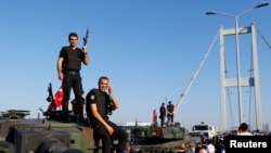 Policemen stand atop military armored vehicles after troops involved in the coup surrendered on the Bosphorus Bridge in Istanbul, Turkey July 16, 2016. 