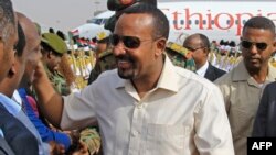 Ethiopia's Prime Minister Abiy Ahmed, center, is welcomed at Khartoum international airport, June 7, 2019. Abiy is seeking to broker talks between the ruling generals and protesters as heavily armed paramilitaries remained deployed in some squares of the Sudanese capital.