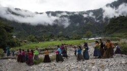 After attending a church service, women and children walk to a communal meeting to try and solve problems associated with housing and donations received by the international community, in the makeshift settlement Nuevo Queja, Guatemala, Sunday, July 11, 2