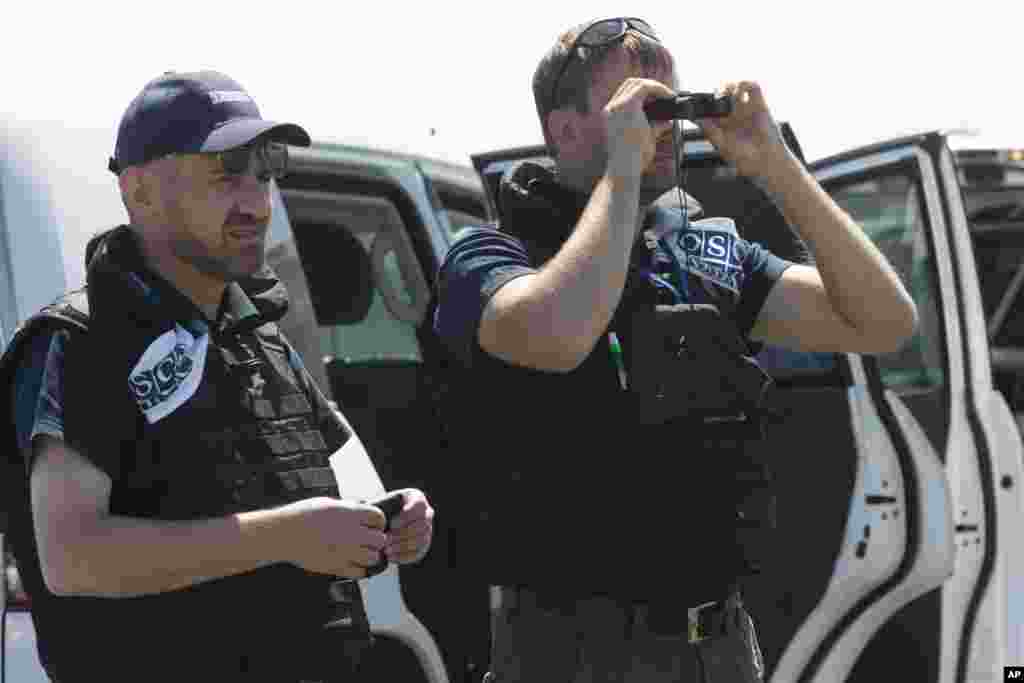 Members of the OSCE mission to Ukraine examine the area of the Malaysia Airlines plane crash near the village of Hrabove, Donetsk region, eastern Ukraine, Aug. 1, 2014.&nbsp;