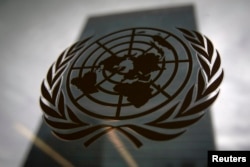 រូបឯកសារ៖ អគារ​អង្គការ​សហប្រជាជាតិ​នៅ​ពីក្រោយបង្អួច​កញ្ចក់ដែល​មាន​រូបបដា​អង្គការ​សហប្រជាជាតិ។