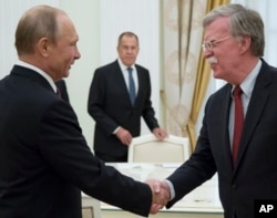 FILE - In this June 27, 2018, photo, Russian President Vladimir Putin, left, and U.S. national security adviser John Bolton greet each other as Russian Foreign Minister Sergey Lavrov looks on during a meeting in the Kremlin in Moscow.