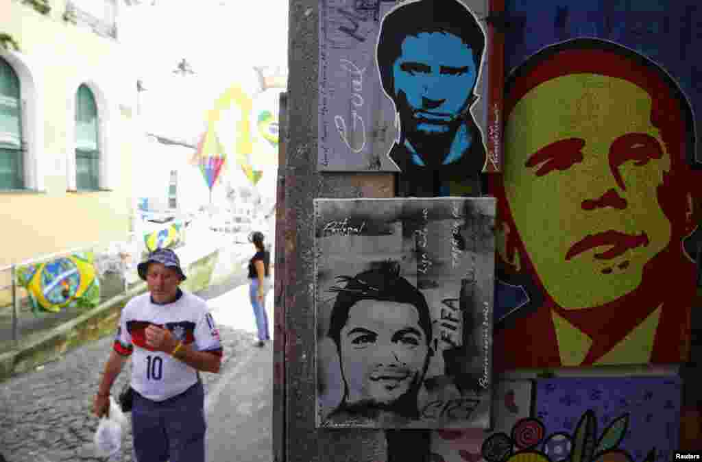 Seni jalanan yang menggambarkan bintang Argentina Lionel Messi, bintang Portugal Cristiano Ronaldo dan Presiden AS Barack Obama di Salvador (15/6).&nbsp;(Reuters/Jorge Silva)