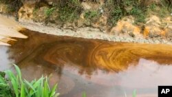FILE - Oil from a spill pollutes the Okuku River in Ogoniland, Nigeria, on Sept. 16, 2023. Amnesty International on July 5, 2024, raised a red flag about two companies the Nigerian government has hired to assess a proposed sale of Shell's onshore assets.