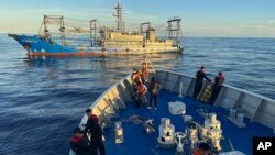 A suspected Chinese militia ship blocks the Philippine coast guard ship BRP Cabra as it approaches Second Thomas Shoal during a resupply mission in the disputed South China Sea on Nov. 10, 2023.